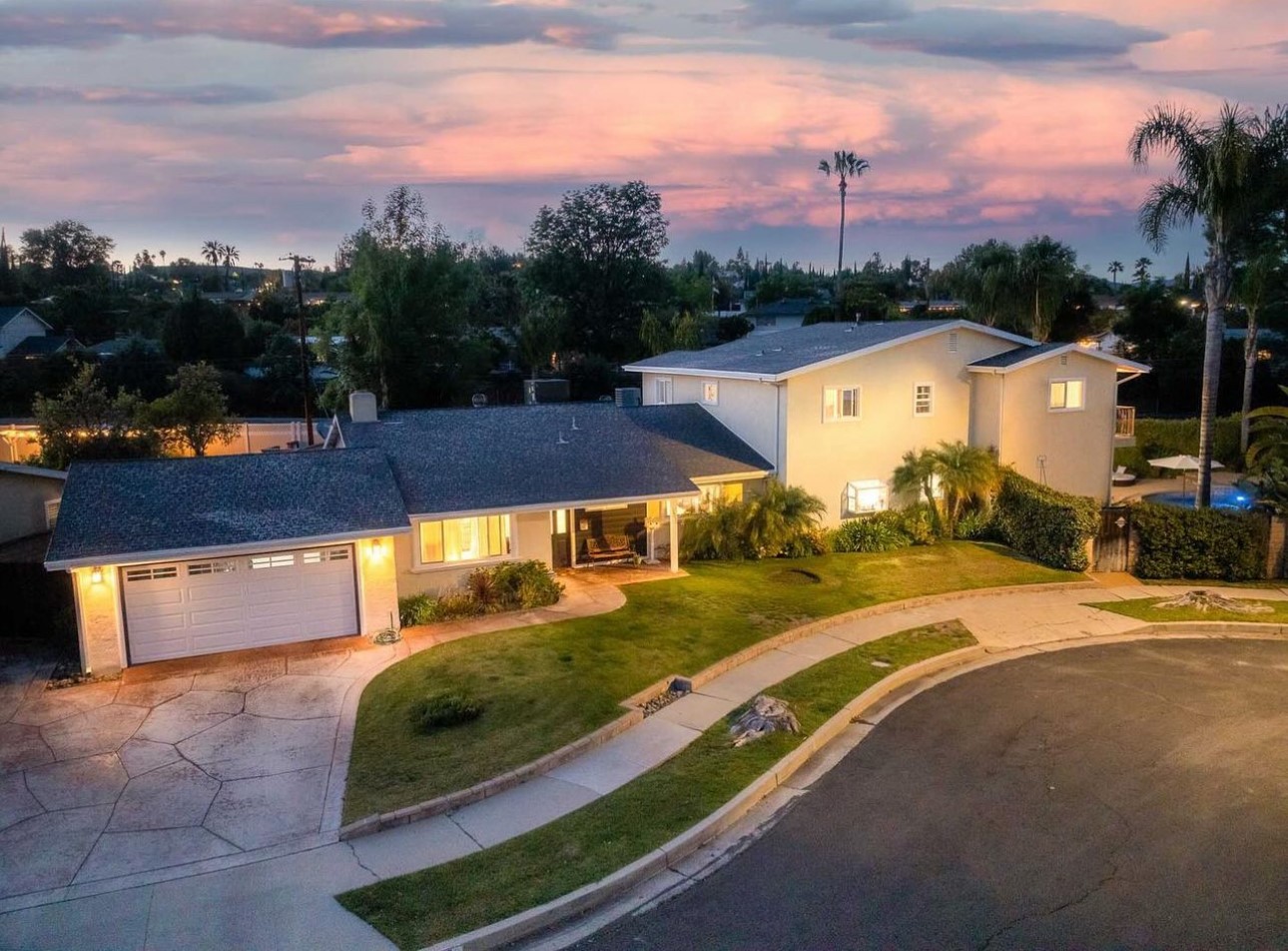 A house with a driveway and a lot of trees