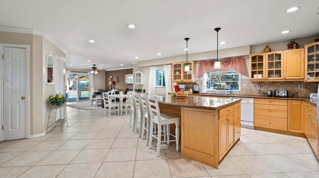 A large kitchen with white chairs and tables