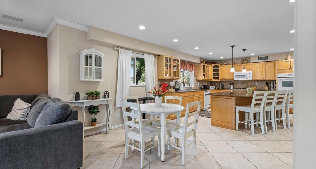 A kitchen with white chairs and tables in it