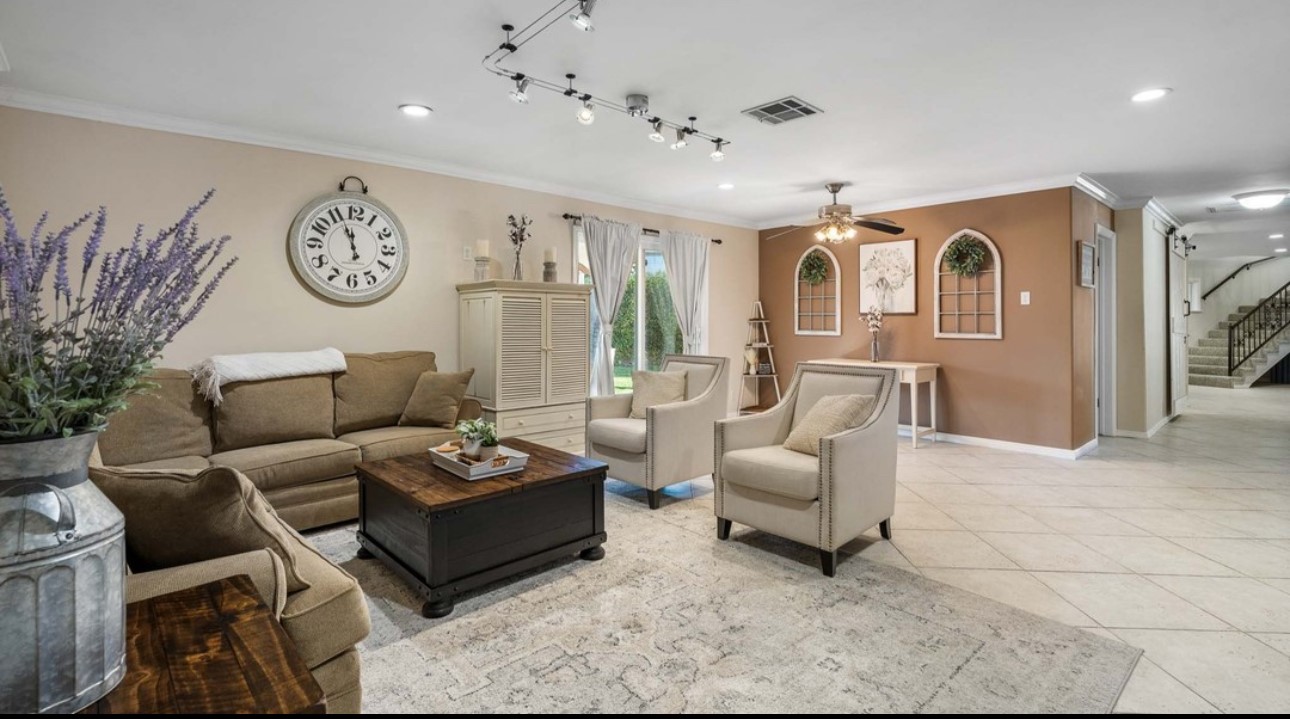 A living room with couches, chairs and tables.