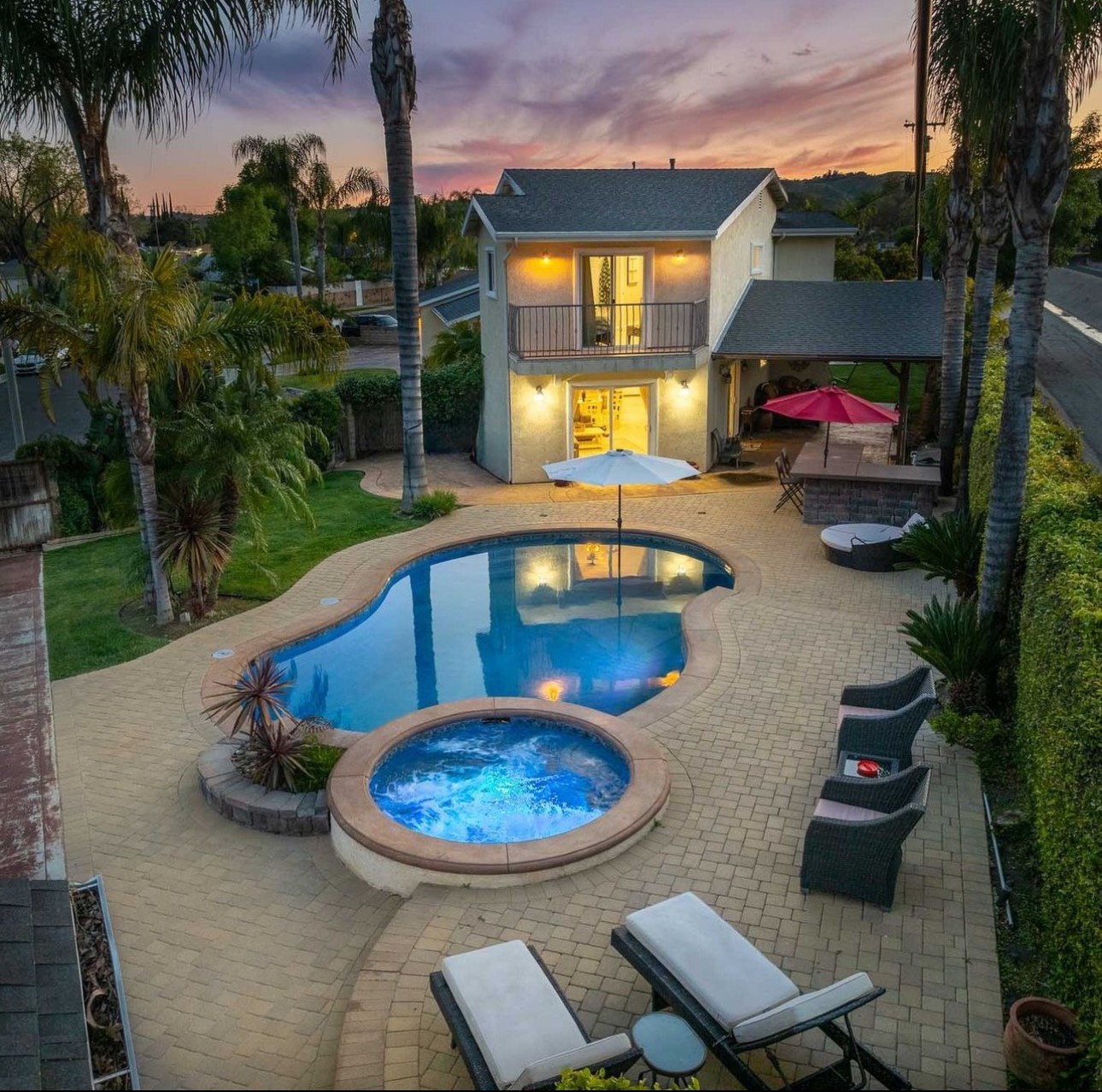 A pool with a jacuzzi and a fire pit.