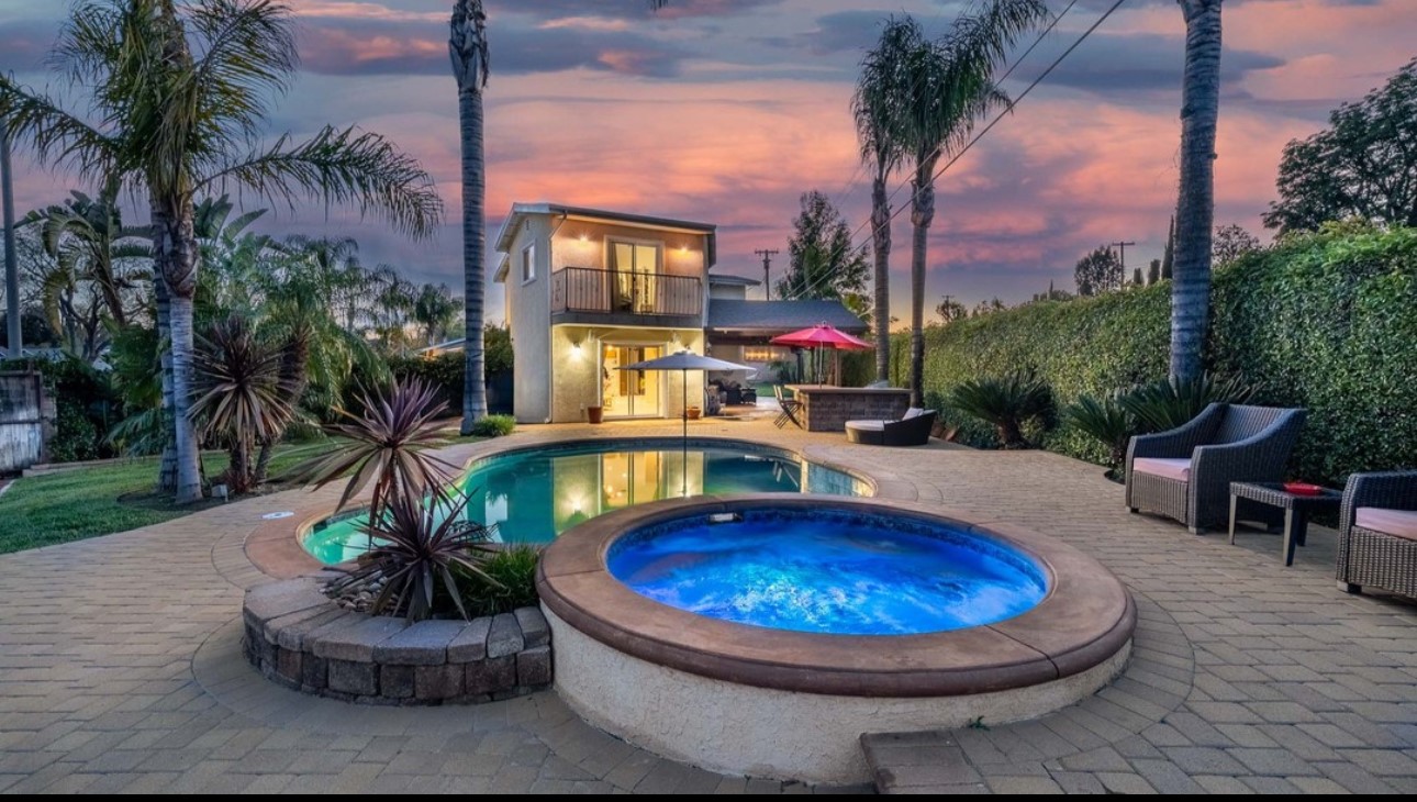 A large pool with a jacuzzi in the middle of it